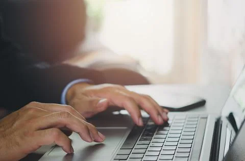 Businessman hand using laptop computer typing keyboard close-up. Online work. Stock Photos