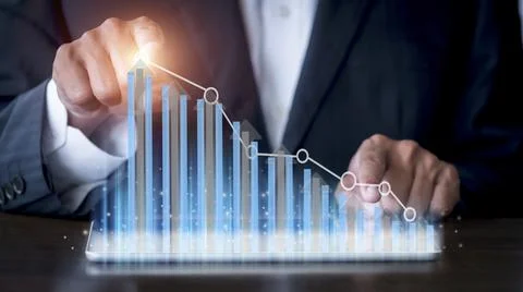 Businessman hand using tablet with creative glowing arrow and stock chart. Ha Stock Photos