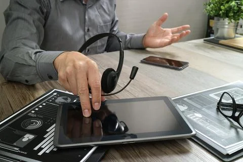 Businessman hand using VOIP headset with digital tablet computer,document,c.. Stock Photos
