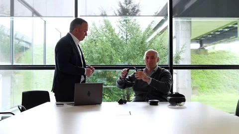 Businessman Handing VR Headset to Client in Bright Modern Office Stock Footage 275861044