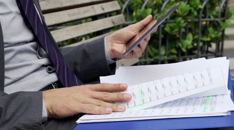 Businessman hands comparing data on tablet computer on  bench in the city  HD Stock Footage 43340838
