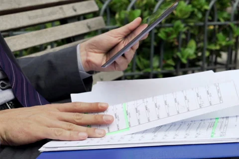 Businessman hands comparing data on tablet computer on  bench in the city NTSC Stock Footage 43340876