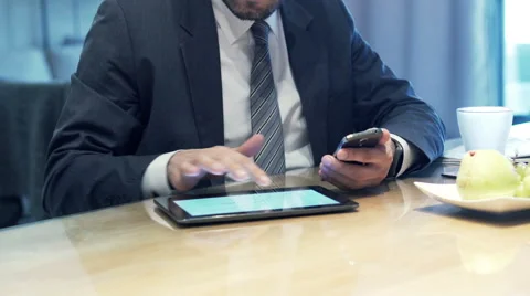 Businessman hands comparing data on tablet computer and smartphone by table a HD Stock Footage 57535318