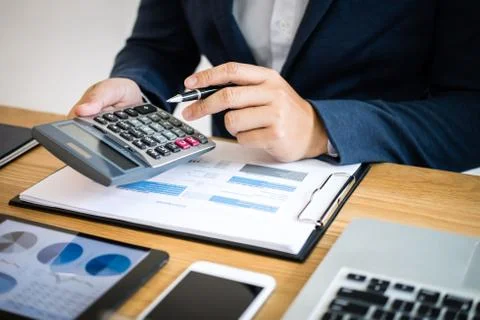 Businessman hands using text information on digital tablet to analyze financi Stock Photos