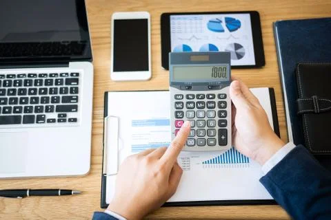 Businessman hands using text information on digital tablet to analyze financi Stock Photos