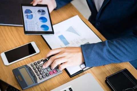 Businessman hands using text information on digital tablet to analyze financi Stock Photos