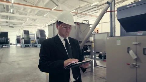 Businessman in hard hat walking through factory Stock Footage 74896677