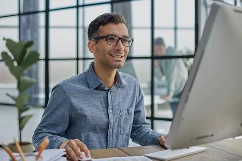 Businessman hard at work on a computer in an office Stock-Fotos