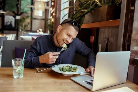 Businessman is having lunch while talking on phone in restaurant. remote work. Stock Photos