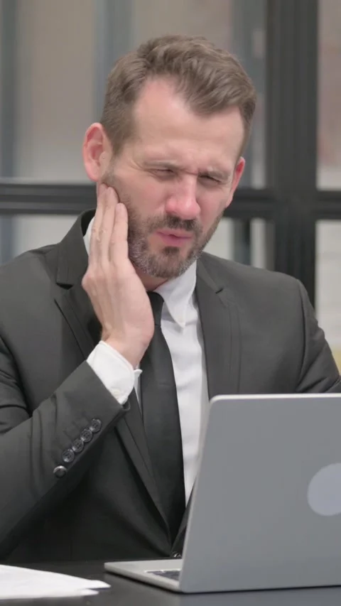 Businessman having Tooth Pain while Working on Laptop, vertical video Stock Footage 324795739