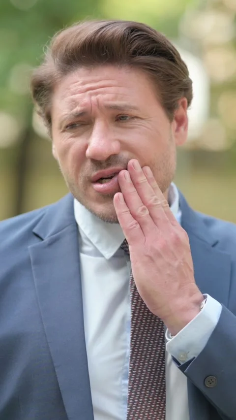 Businessman Having Toothache while Standing Outside Office, vertical Stockbeeldmateriaal 321119770