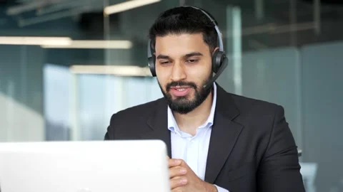 Businessman in a headset talking on video call conference using laptop computer  Stock Footage 318218405