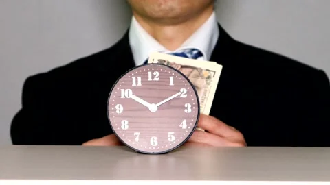 A businessman holding banknotes in front of a clock Video stock 334990877