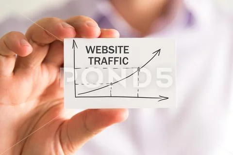 Businessman holding a card with WEBSITE TRAFFIC rising arrow and chart Stock Photos