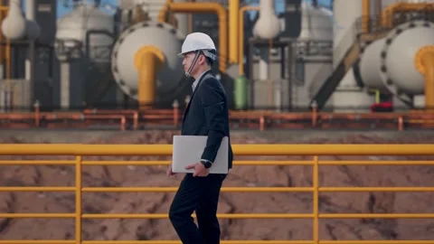 Businessman Holding Computer While Walking at Energy Plant Stock Footage 331192466