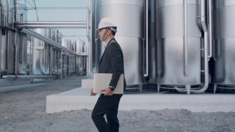 Businessman Holding Computer While Walking at Chemical Plant Stock Footage 332549909