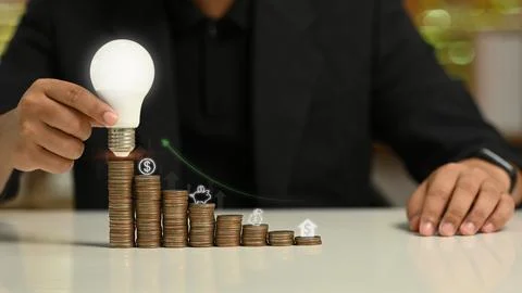 Businessman holding glowing light bulb with virtual hologram. Investment and 写真素材