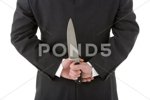 Businessman holding knife behind his back Stock-Fotos