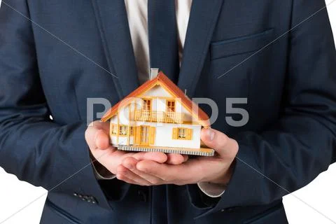 Businessman holding miniature house model Stock-Fotos