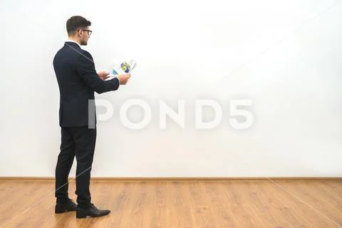 The businessman holding papers on the white wall background Stock Photos