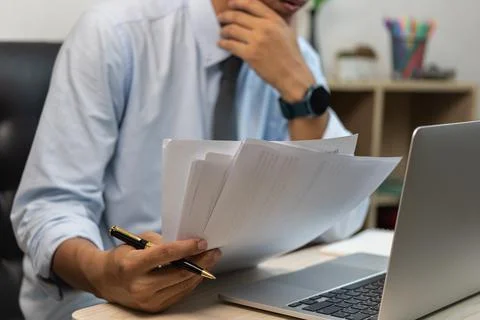 Businessman holding paperwork document graph report accounting and finance in Stock Photos