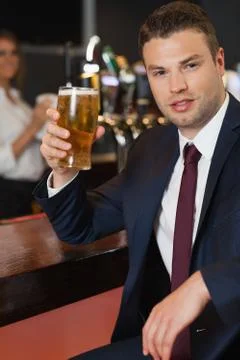 Businessman holding a pint of beer smiling at camera Stock Photos