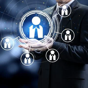 Businessman holding virtual interface with human icons, representing HR man.. Stock Photos