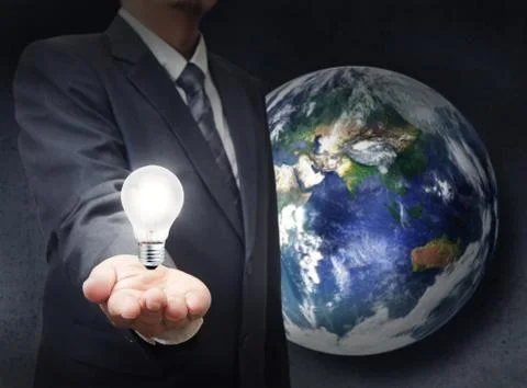 Businessman holds light bulb to glowing the earth Illustrazione stock