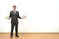 The businessman holds papers on the white wall background Photo