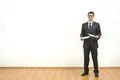 The businessman holds papers on the white wall background Photo