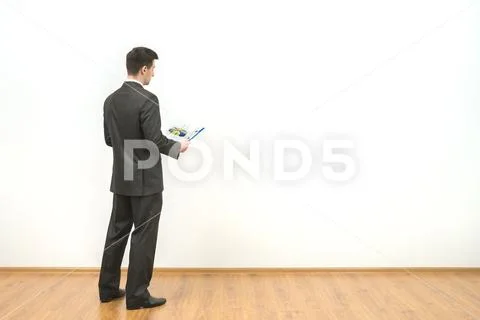 The businessman holds papers on the white wall background Stock Photos