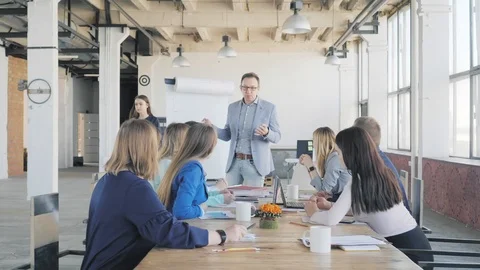 A businessman holds a presentation using a flipchart and communicates with Stock Footage 111646496