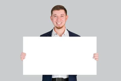 A businessman holds a rectangular white blank board with a place for text in  Stock Photos