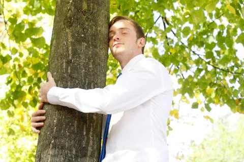 Businessman hugging tree Stock Photos