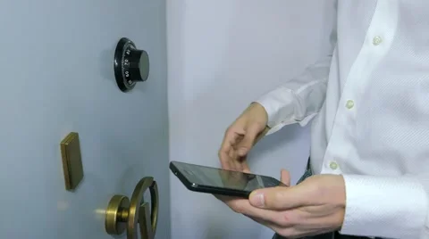 Businessman insert the combination to the safe, writing cellphone Stock Footage 61948447