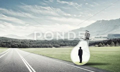 Businessman inside light bulb Stock Photos