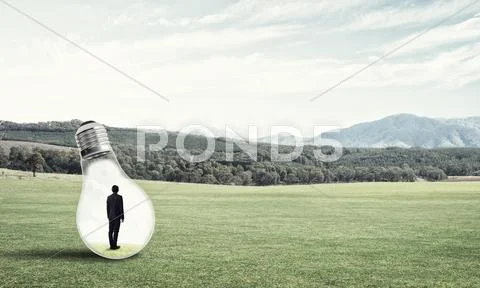 Businessman inside light bulb Stock Photos