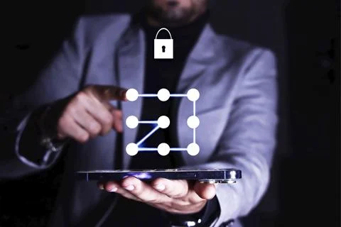 A businessman interacting with a digital security pattern displayed above a Stock Photos