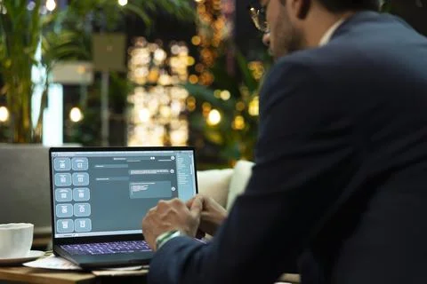 Businessman interacts with generative AI chatbot on laptop Stock Photos