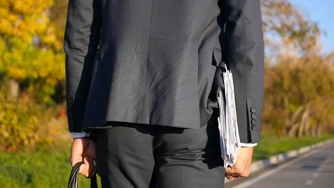 A businessman in a jacket with papers and a briefcase rides on a skateboard Stock Footage 114601357