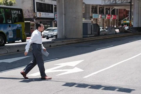 Businessman Jaywalking Across Intersection Under MRT Elevated Tracks Taipei Stock-Fotos