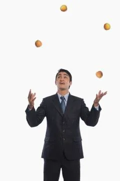 Businessman juggling with apples Stock Photos