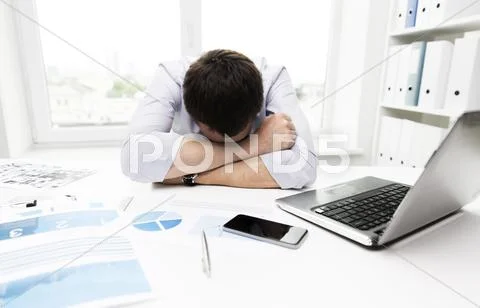 Businessman with laptop and papers in office Stock Photos