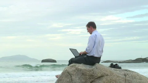 Businessman with laptop on the beach Stock Footage