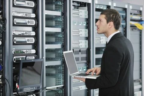Businessman with laptop in network server room Stock Photos