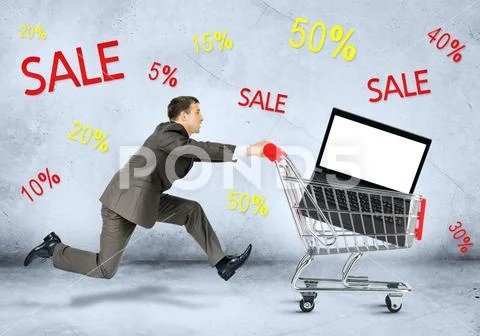 Businessman with laptop in shopping cart Stock Photos