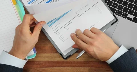 Businessman leafing through documents at workplace in office Video stock 266776410