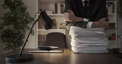Businessman leaning over stack of paperwork Stock Footage 143109938