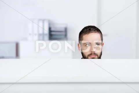 Businessman looking away in office cubicle Stock Photos