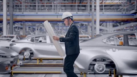 Businessman Looking At Blueprint In Hands While Walking In Car Factory Stock Footage 331630213